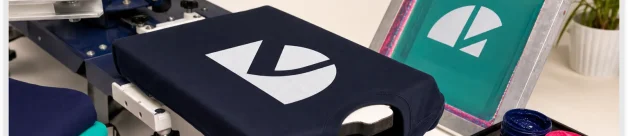 Screen printing press showing dark shirt underbase and bright ink setup
